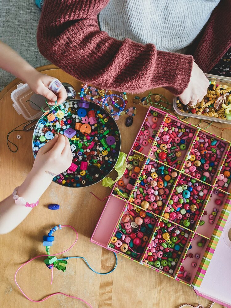 People making bracelets with colored beads