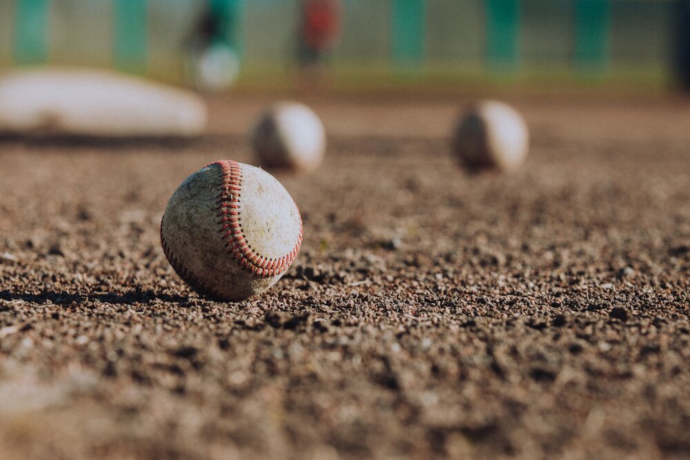 Baseballs in the dirt of a baseball field