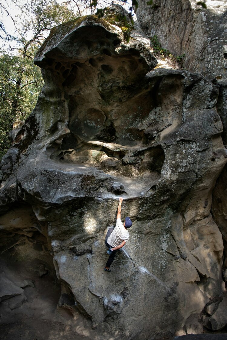 Someone free rock climbing outdoors on a natural rock structure