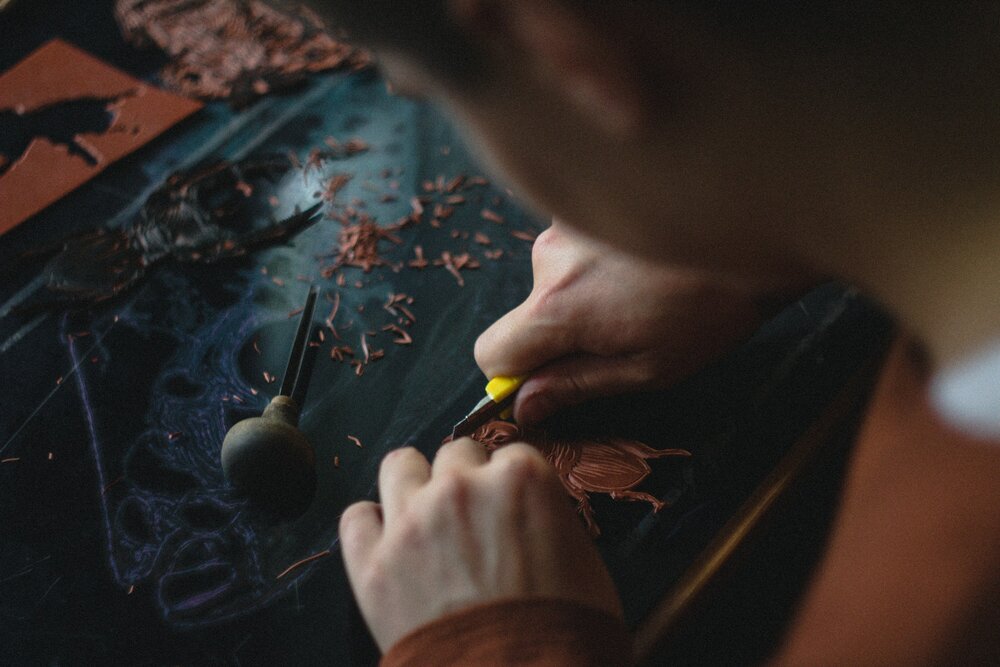 Someone carving a bug out of wood 