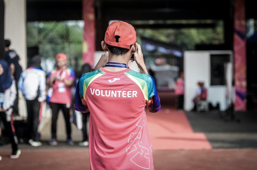 The back of someone wearing a red 'Volunteer' shirt