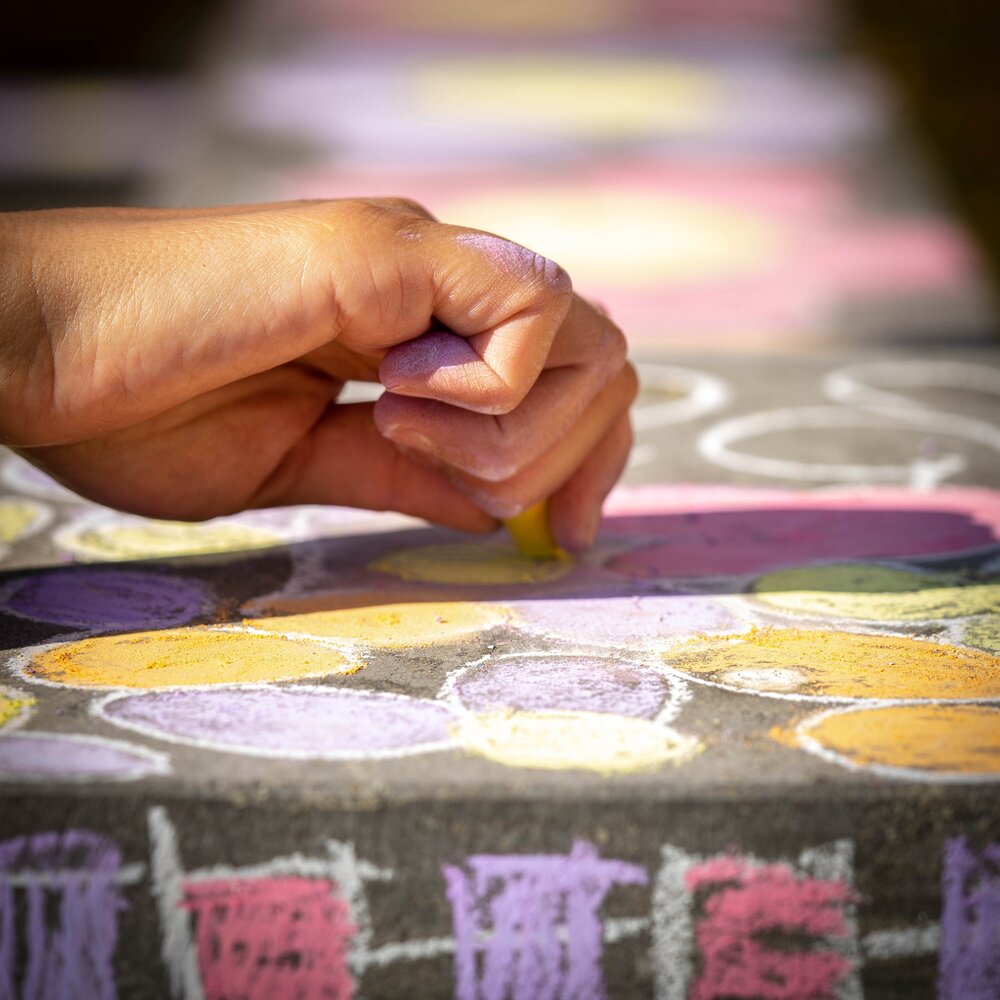 A hand drawing on the concrete with colorful chalk