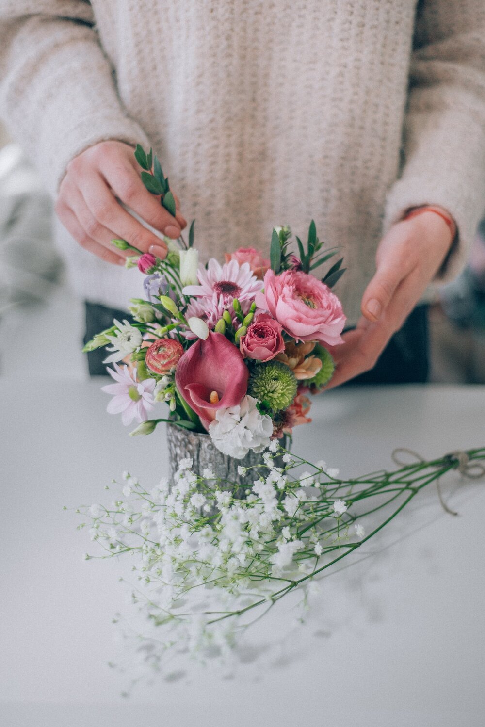 Someone making a colorful floral arrangement