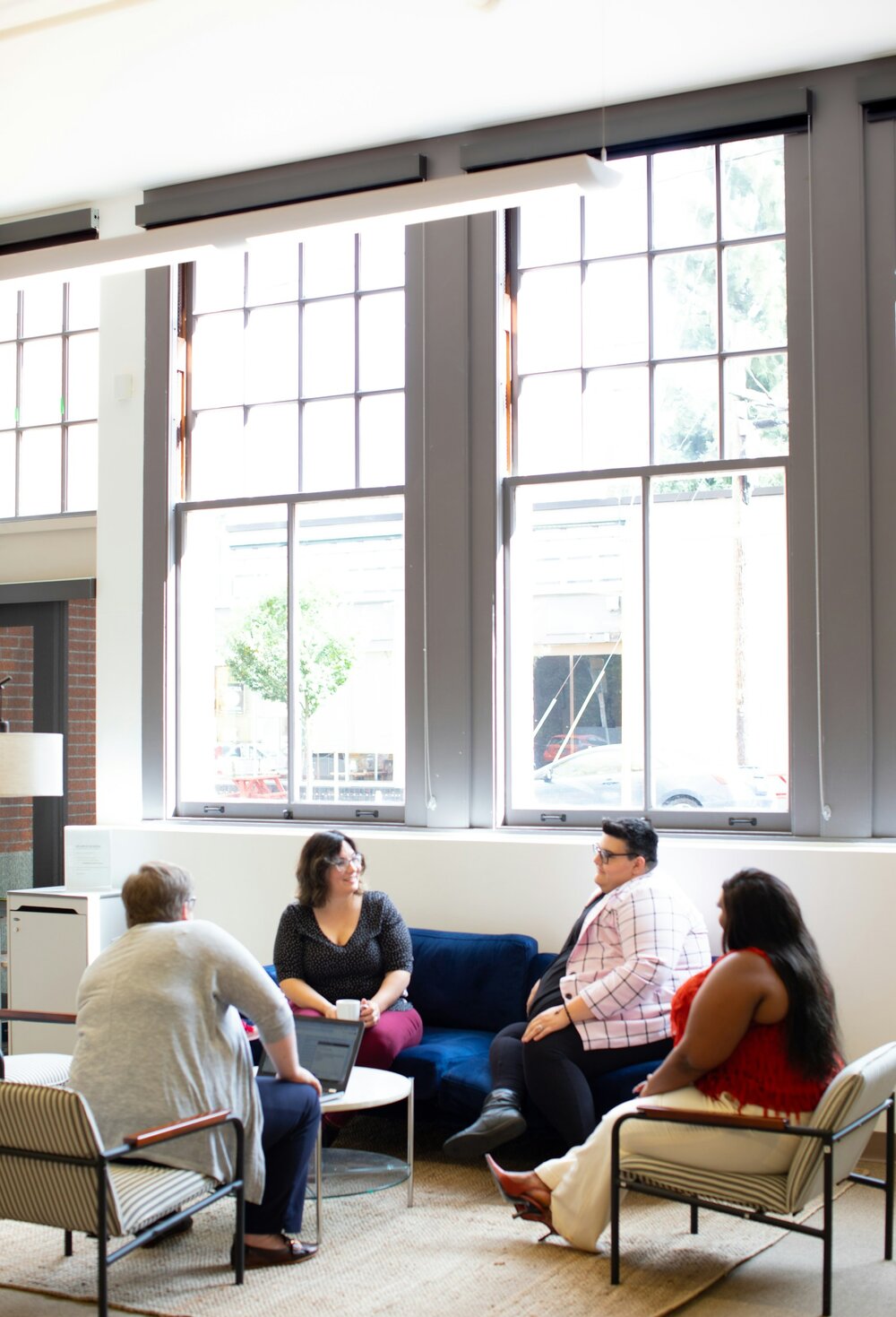 A group of people sitting in a circle and talking in an indoor environment