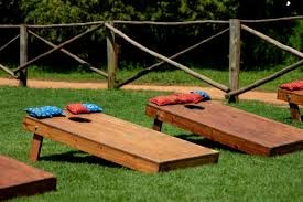 A line of cornhole boards and beanbags