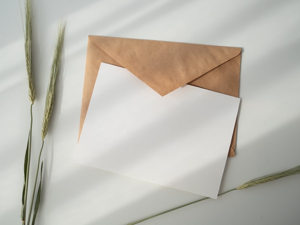 a blank card sitting on top of a brown envelope