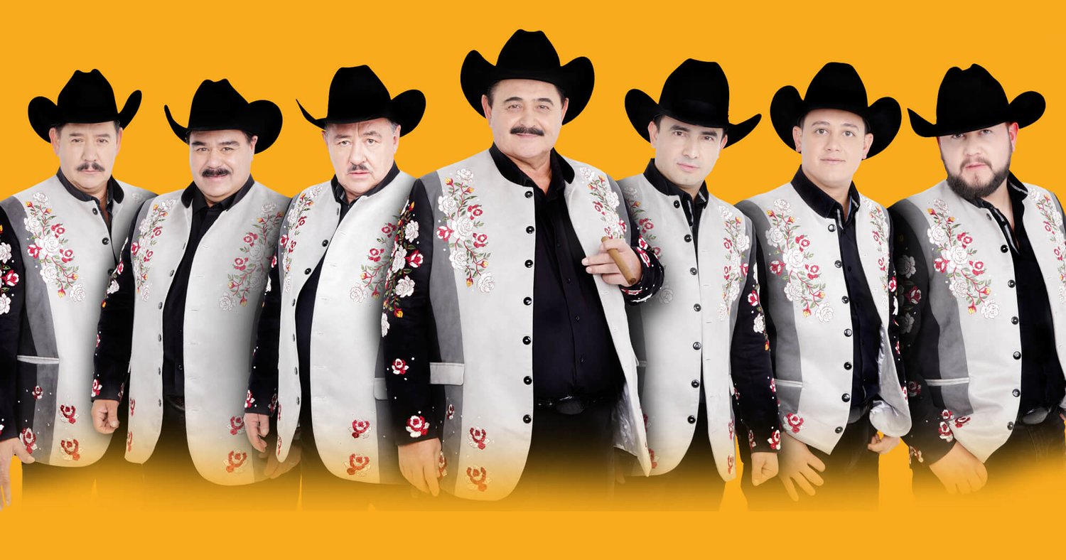 The seven members of Los Huracanes del Norte posing in matching outfits