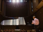 Person standing at a piano 