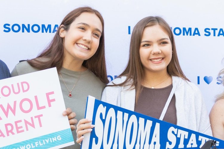 People smiling and posing with SSU signs on Move In Day