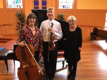 The members of the Navarro Trio smiling and posing with their instruments 