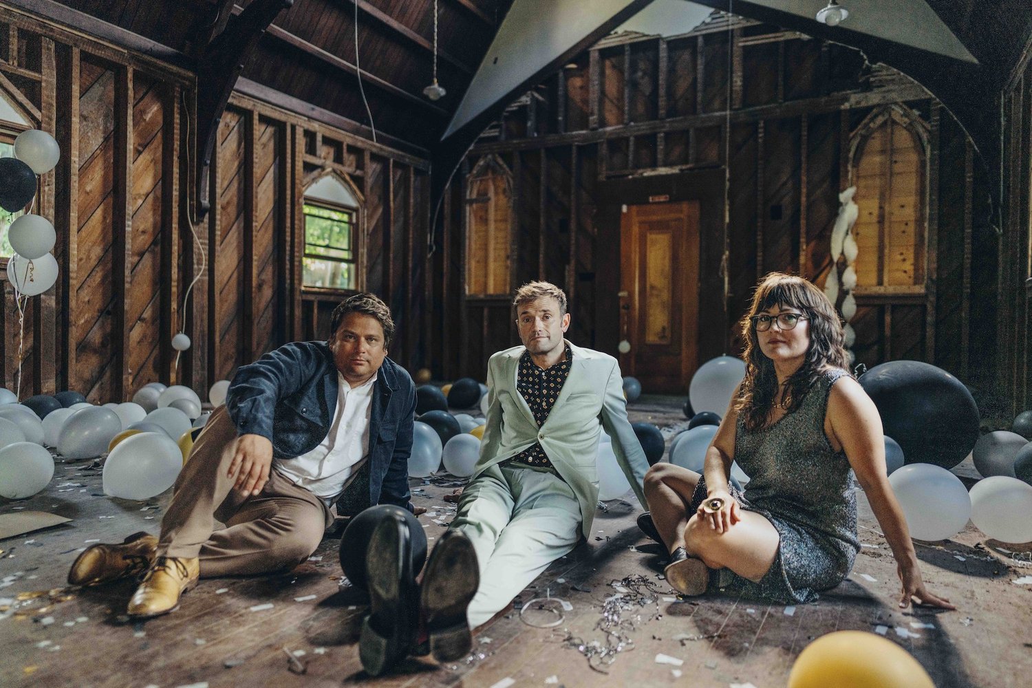 The members of Nickel Creek sitting and posing in an indoor setting