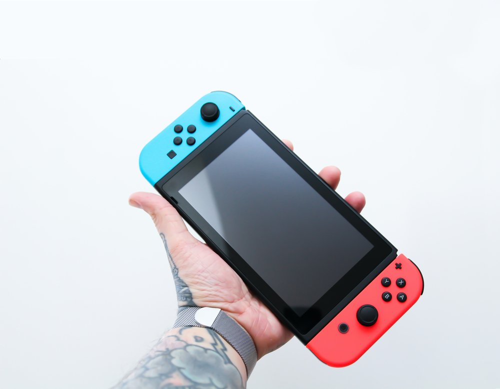 a person holding a Nintendo Switch