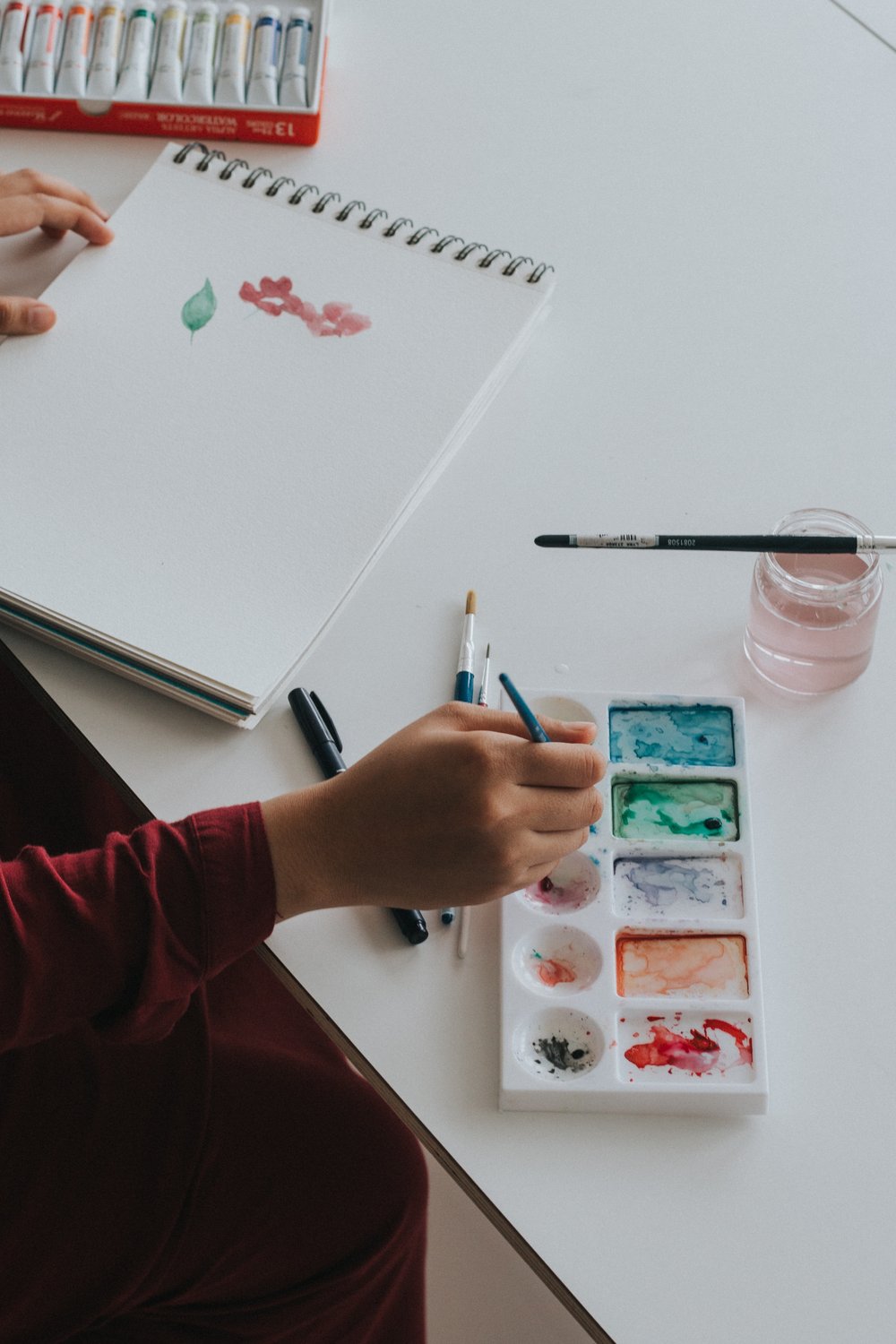 a person painting with watercolor paints