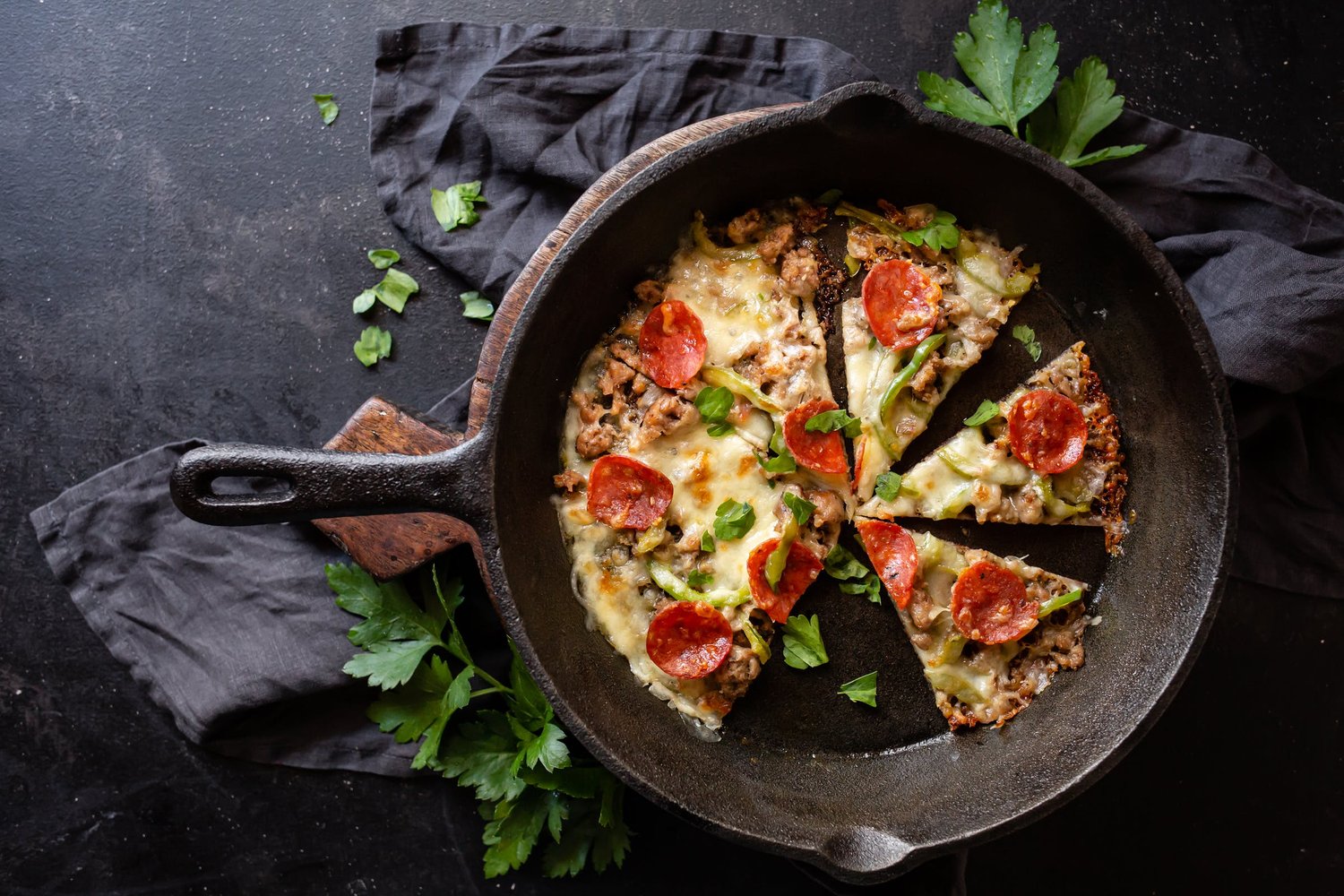 A fresh pizza inside of a cast iron pan