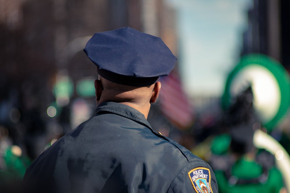 an African American police officer with his back facing the viewer