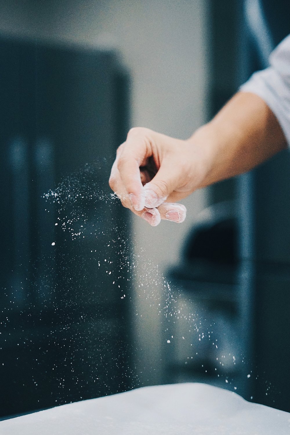 a hand sprinkling flour while cooking