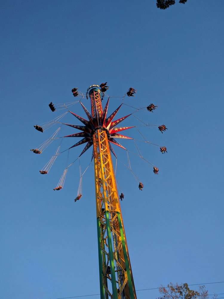 A carnival yo-yo ride with people spinning on swings 