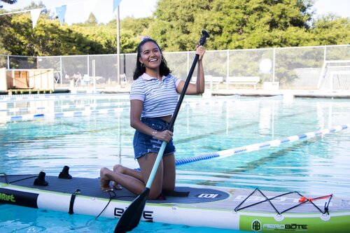 Student paddle boarding in the pool 