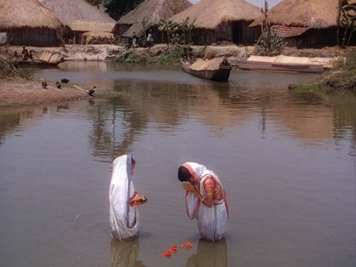 Two people praying in a river