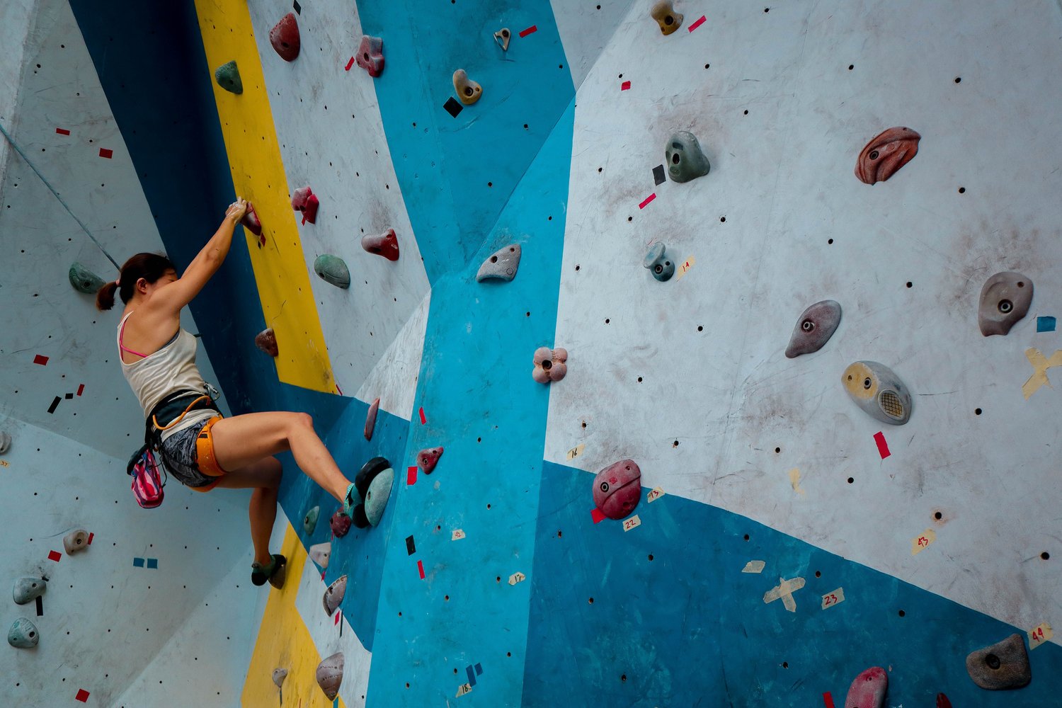 A person climbing on a colorful indoor rock wall