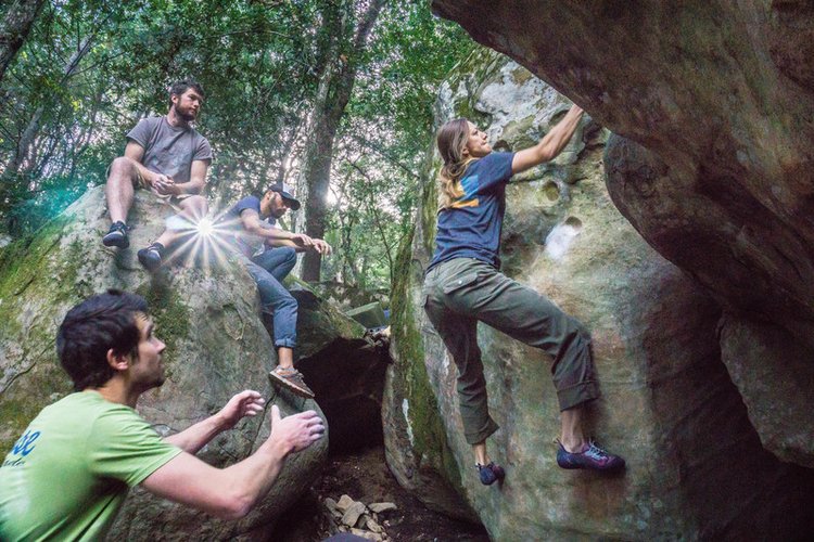 A group of people bouldering outdoors 