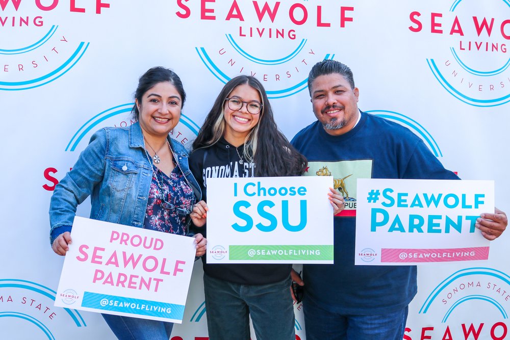 a new Seawolf and their parents holding signs that say they are proud Seawolf parents and that the new student chose SSU