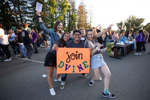 Students holding up a club poster