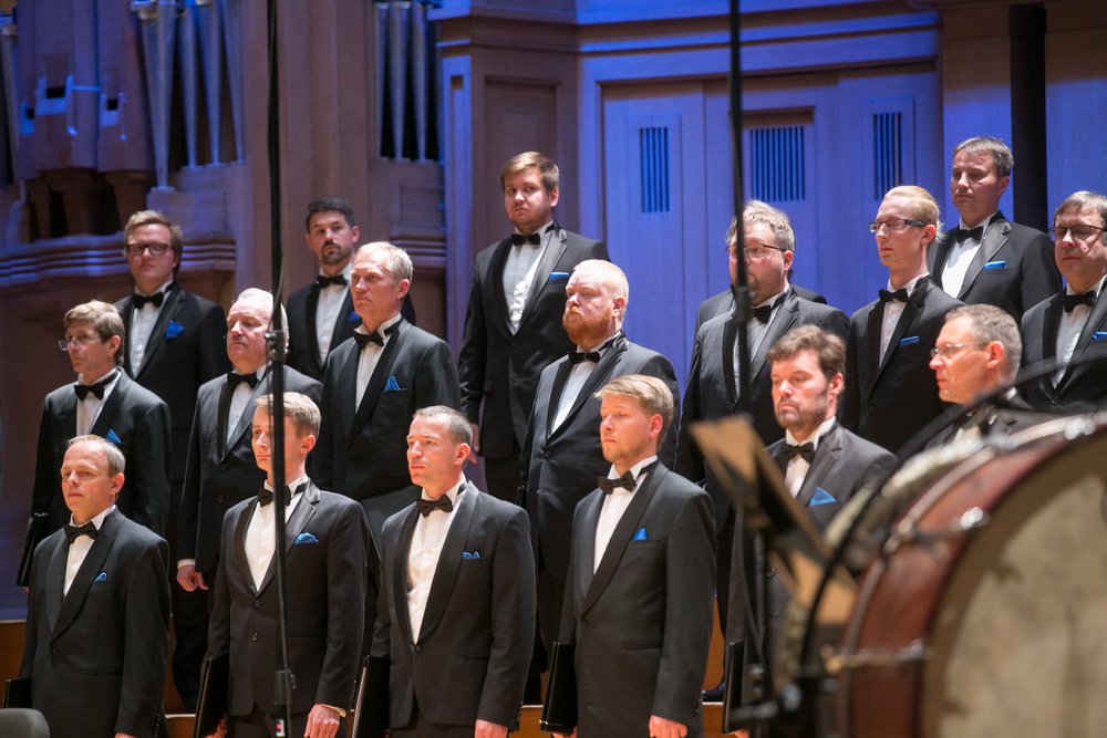 a group of people singing on a stage