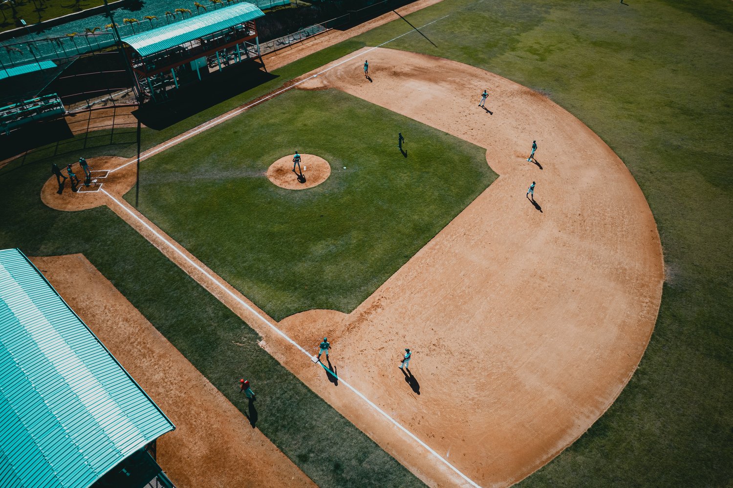 An aerial view of people playing softball on a softball field 