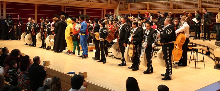 Musicians standing in a line on the indoor GMC stage 