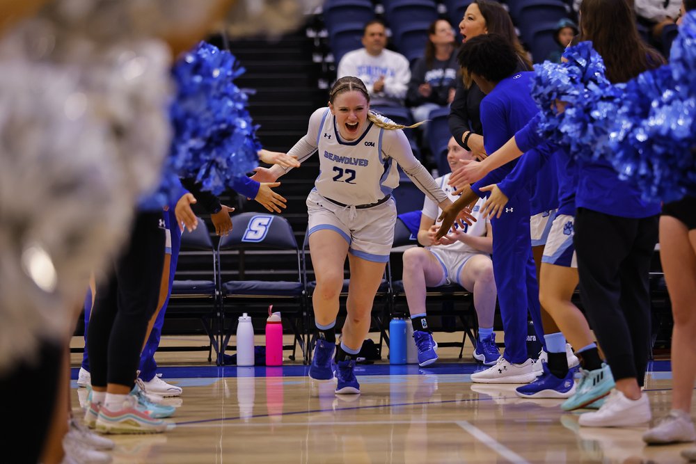 SSU Women's Basketball player Emerson Herrmann running between two rows of people while high-fiving them
