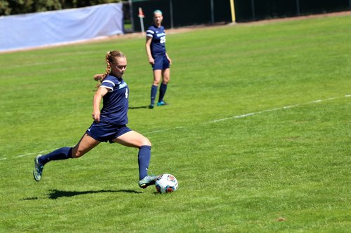 Student kicking a soccer ball 