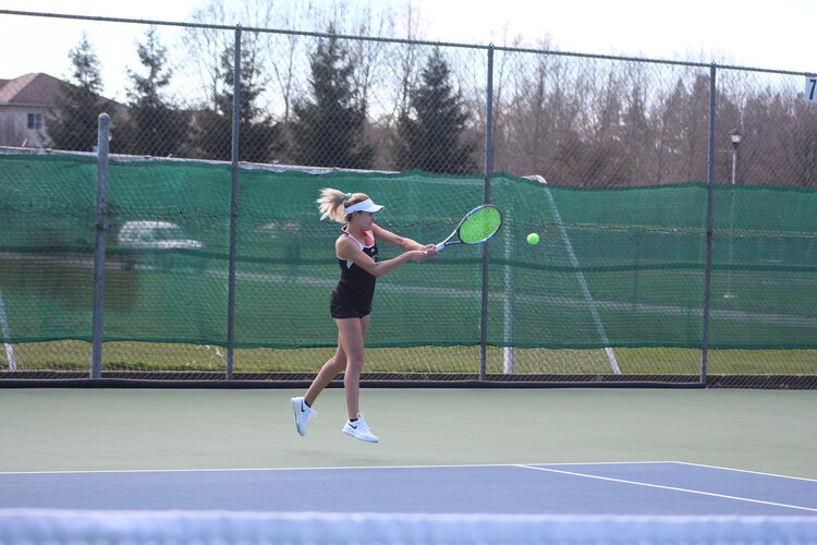 Student playing tennis 