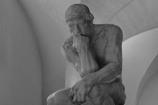 Statue A carved statue of a person resting their head on the fist