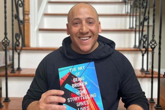Kevin Hines smiling with book