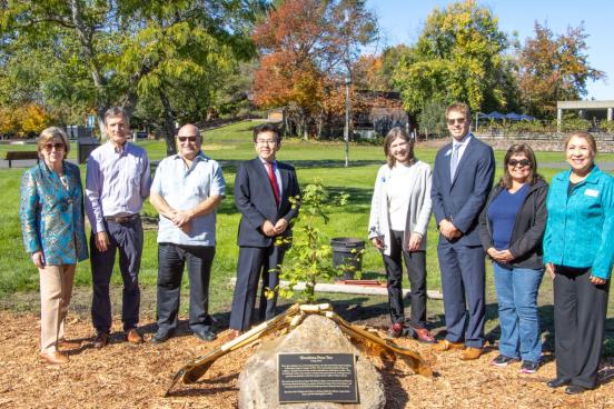 A crowd of people posing next to the Peace Tree at SSU