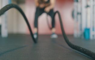 person using battle ropes at gym