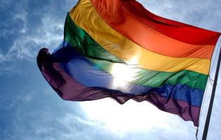 a pride flag billowing in the wind