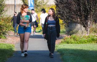 Two students walking on SSU's campus by Ives Hall