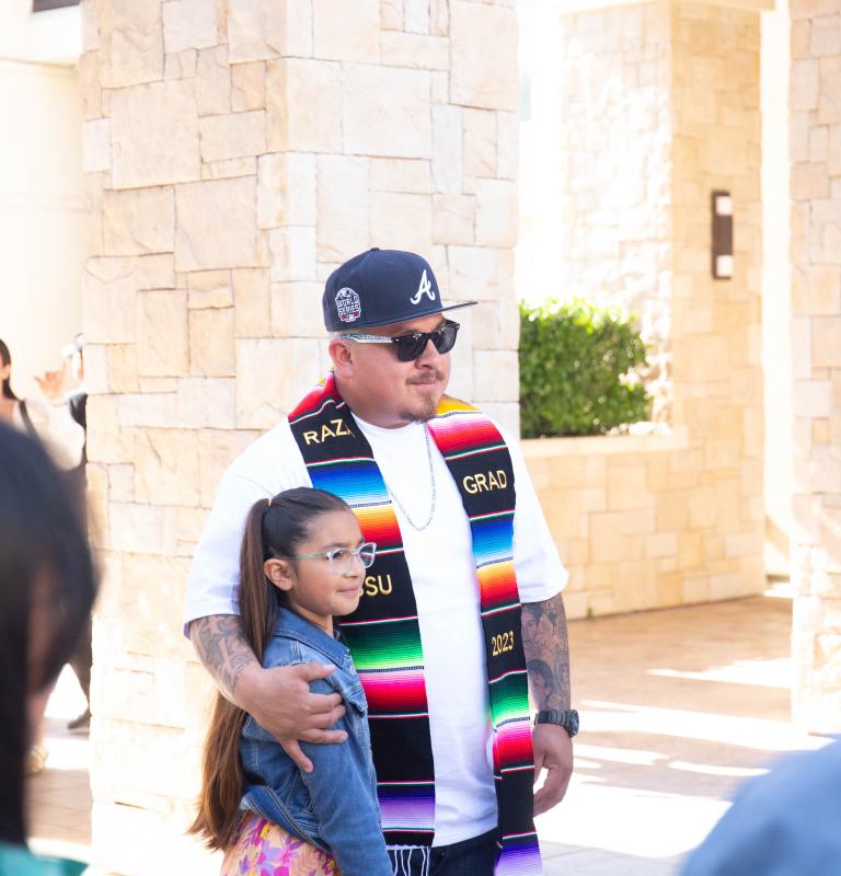 Graduate taking a photo with his daughter