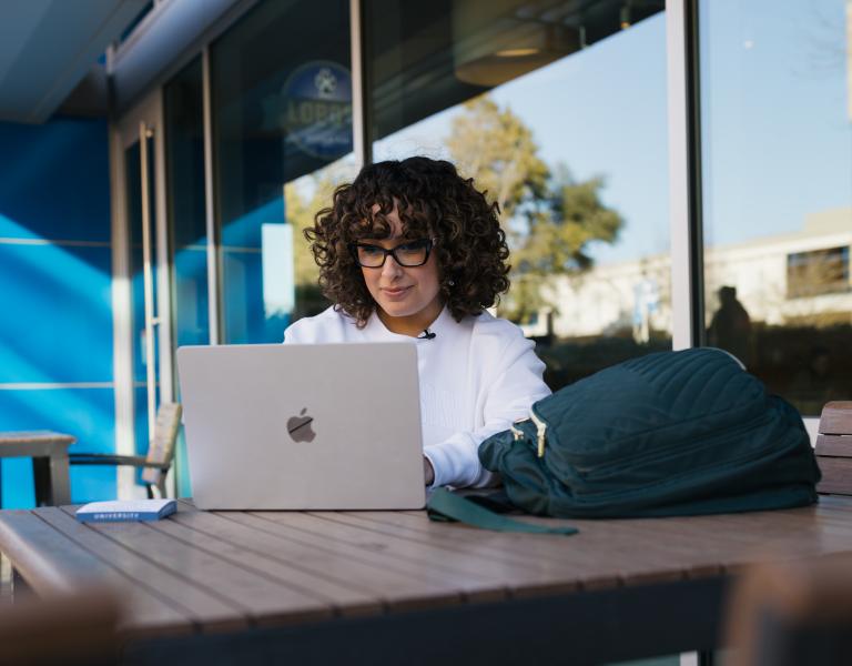 Student looking for campus resources on her laptop