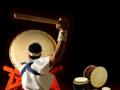 The back of someone beating a Taiko drum 