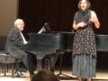 A person singing and a person playing piano on stage at the Vocal Repertory Recital