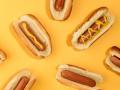Hot dogs in front of a yellow background
