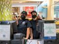 Cashiers posing in face masks behind their cash registers