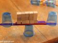 A balanced stack of plastic cups, wooden popsicle sticks, and wood cubes