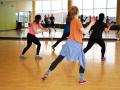 People dancing in front of a mirror in an indoor dance class