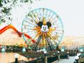 Disney outdoor theme park featuring a ferris wheel with Mickey Mouse's face on it 