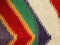 Knitted fabric with white, red, purple, green, and gold details 