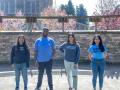 four Sonoma State University students standing in a row in front of the Alumni Amphitheater at Sonoma State University.